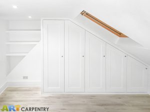 Traditional sloping wardrobe and floating shelves fitted in the loft spare room