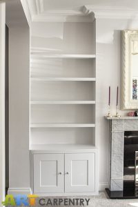 Alcove fitted TV cabinets with bookshelves besides the chimney