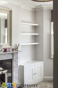 Alcove fitted TV cabinets with bookshelves besides the chimney