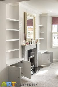 Alcove fitted TV cabinets with bookshelves besides the chimney