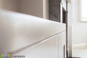 Alcove fitted TV cabinets with bookshelves besides the chimney