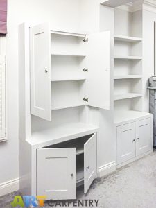 Alcove fitted TV cabinets with bookshelves besides the chimney