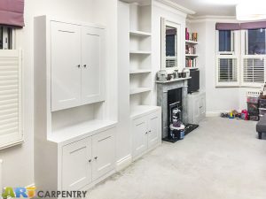 Alcove fitted TV cabinets with bookshelves besides the chimney