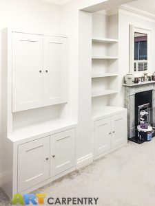 Alcove fitted TV cabinets with bookshelves besides the chimney