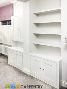 Alcove fitted TV cabinets with bookshelves besides the chimney